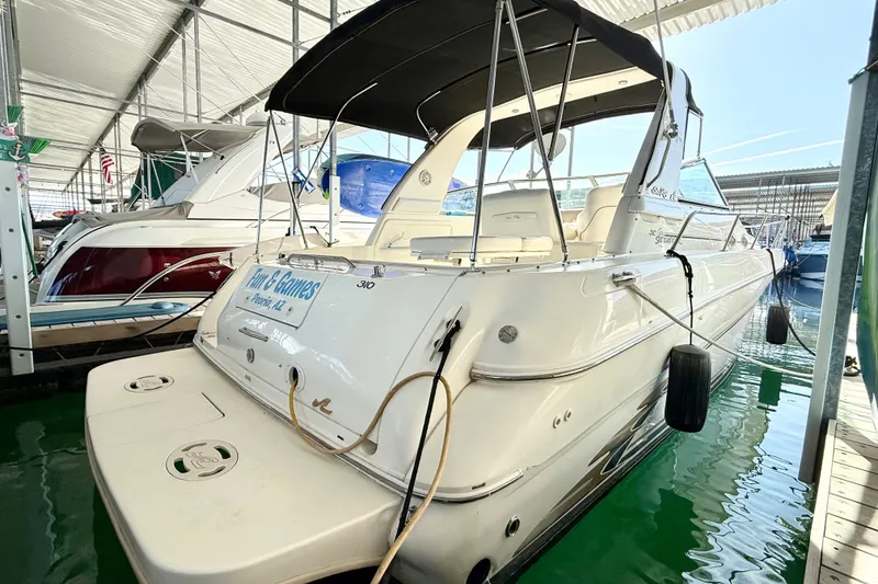 The Image of 1998 Sea Ray Sundancer 310 docked in a marina, featuring a sleek white design. - 0