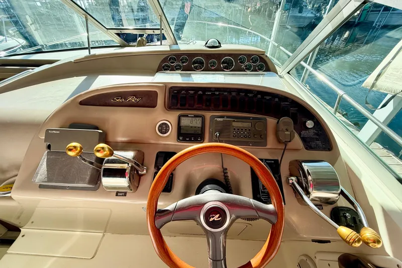 Slide: The Image of 1998 Sea Ray Sundancer 310 helm with wood steering wheel and control panel. - 10