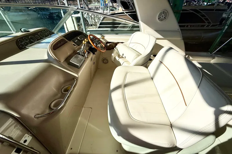 Slide: The Image of 1998 Sea Ray Sundancer 310 cockpit with beige leather seating and steering wheel. - 11