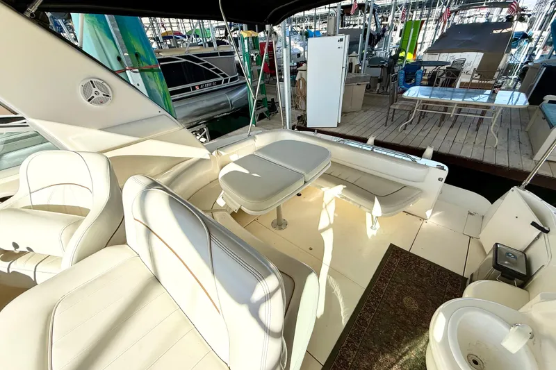 Slide: The Image of 1998 Sea Ray Sundancer 310 boat interior with white seating and table at marina. - 12
