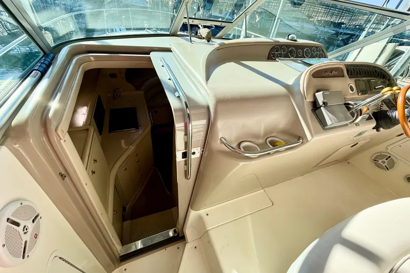Slide: The Image of 1998 Sea Ray Sundancer 310 cockpit with cabin entrance, showcasing helm controls and dashboard. - 15