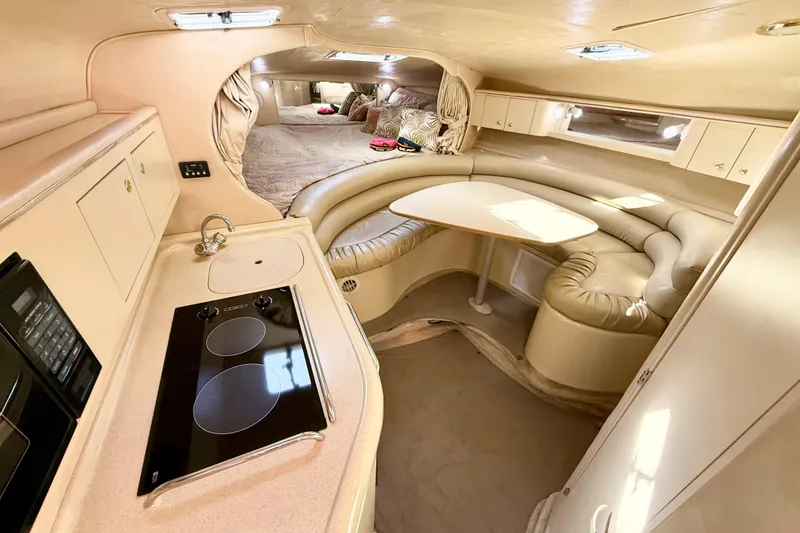 Slide: The Image of Interior of 1998 Sea Ray Sundancer 310, featuring kitchen, seating, and sleeping area. - 16