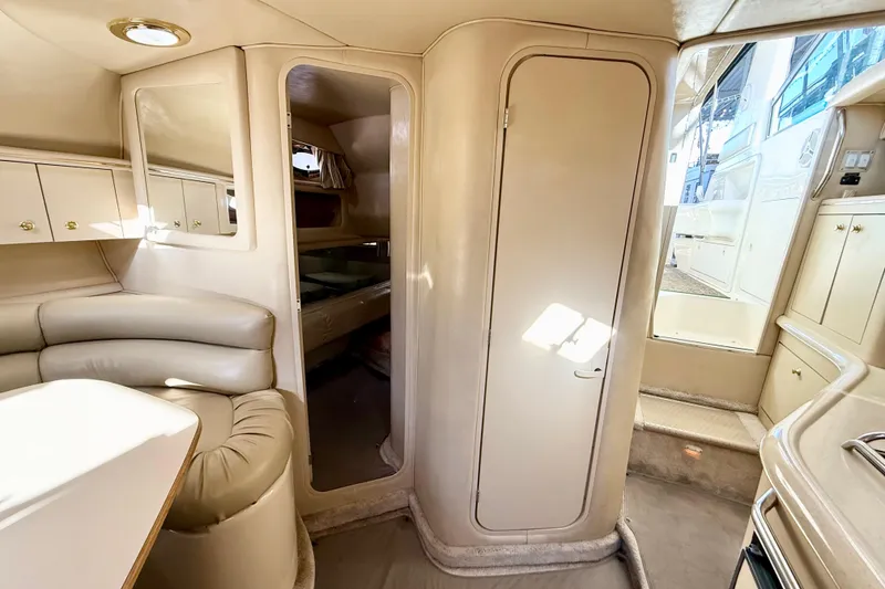 Slide: The Image of 1998 Sea Ray Sundancer 310 cabin interior with beige seating and cabinetry. - 20