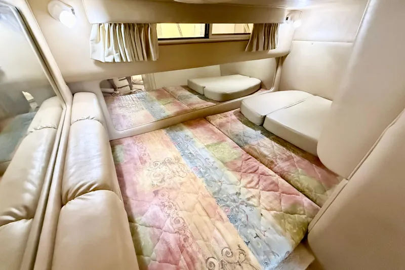 Slide: The Image of 1998 Sea Ray Sundancer 310 cabin interior with colorful bedding and mirrored wall. - 24