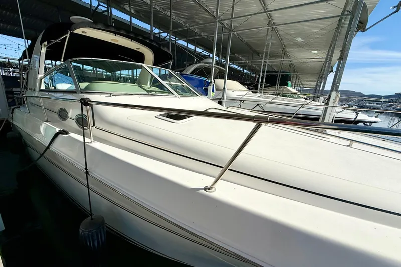 Slide: The Image of 1998 Sea Ray Sundancer 310 docked in a marina under a covered structure. - 6