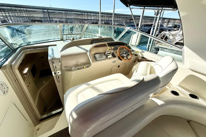 Slide: The Image of 1998 Sea Ray Sundancer 310 cockpit with leather seats and wooden steering wheel. - 9