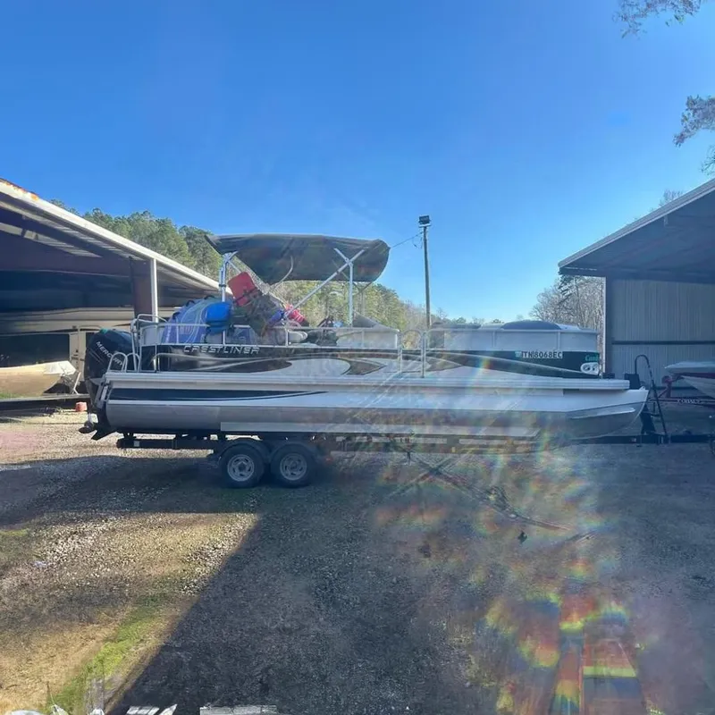 The Image of 2008 Crestliner Grand Cayman 2585 pontoon boat on trailer outdoors. - 0
