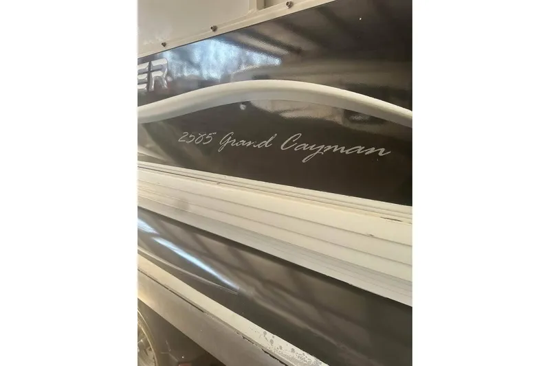 Slide: The Image of 2008 Crestliner Grand Cayman 2585 boat side view with model name visible. - 10