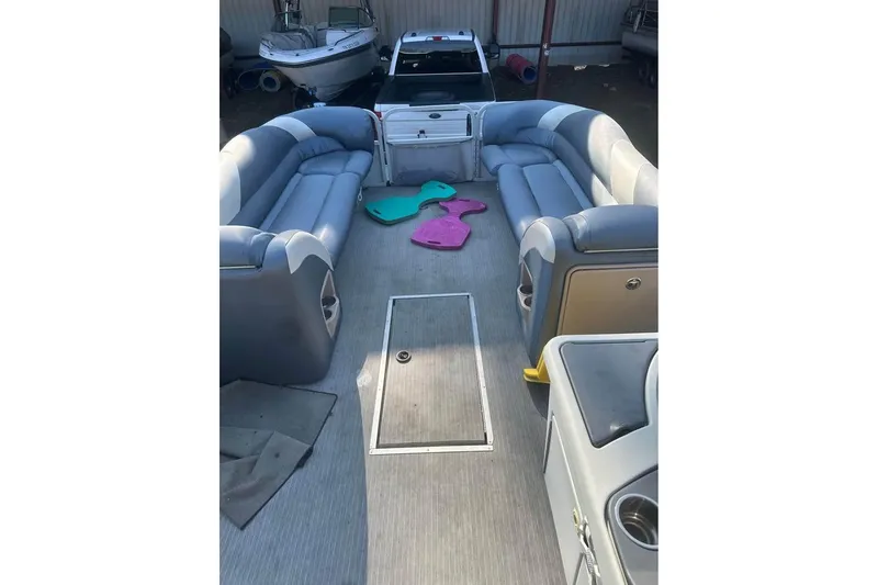 Slide: The Image of 2008 Crestliner Grand Cayman 2585 pontoon boat interior with spacious seating and colorful mats. - 7