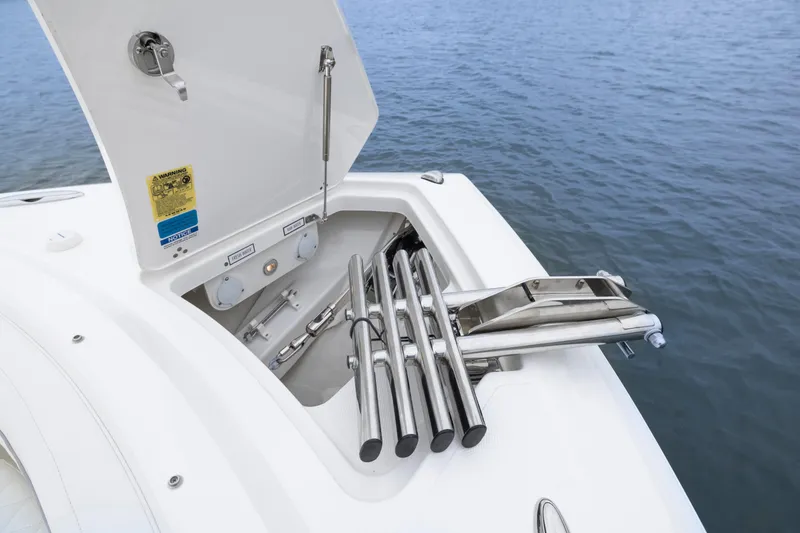 Slide: The Image of 2026 Pursuit DC 286 Dual Console boat with open storage compartment and stainless steel fittings. - 11