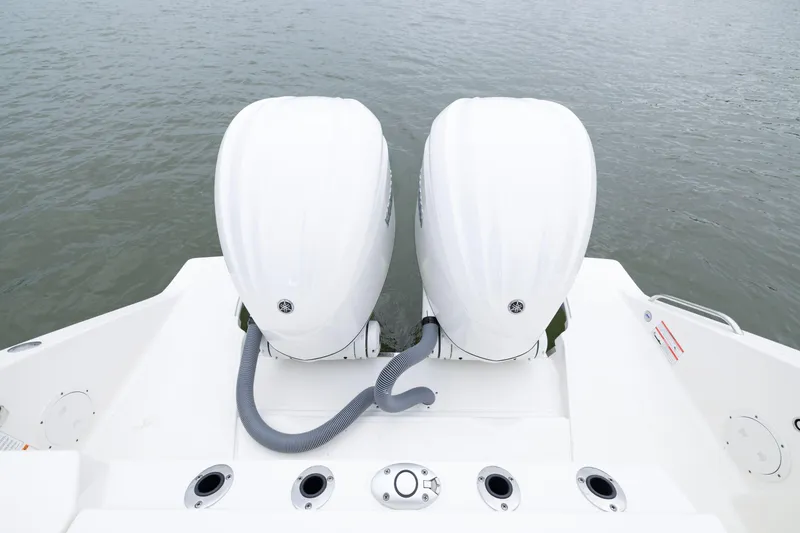 Slide: The Image of 2026 Pursuit DC 286 Dual Console boat with twin outboard engines on water. - 12