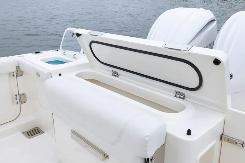 Slide: The Image of 2026 Pursuit DC 286 Dual Console boat with open storage compartment and twin engines. - 13