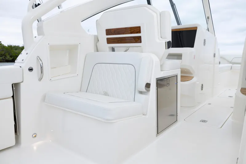 Slide: The Image of 2026 Pursuit DC 286 Dual Console boat interior with white seating and storage compartments. - 19