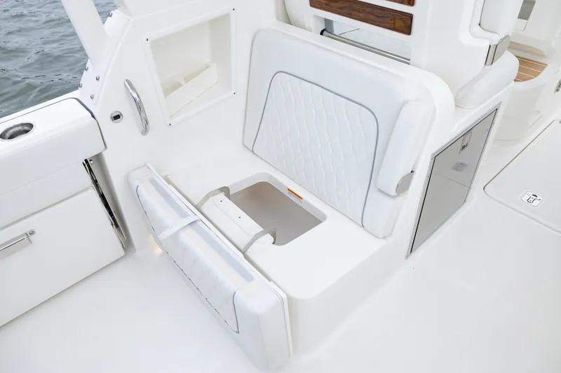 Slide: The Image of 2026 Pursuit DC 286 Dual Console boat interior with white seating and storage compartments. - 20