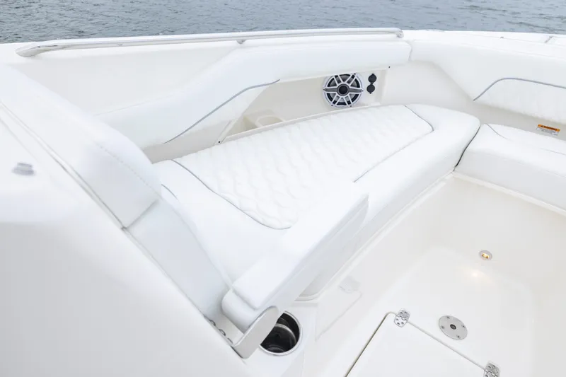 Slide: The Image of 2026 Pursuit DC 286 Dual Console boat interior with white seating and speaker. - 33
