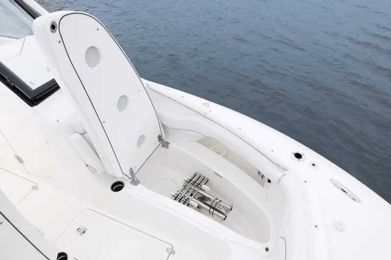 Slide: The Image of 2026 Pursuit DC 286 Dual Console boat with open storage compartment by the water. - 34
