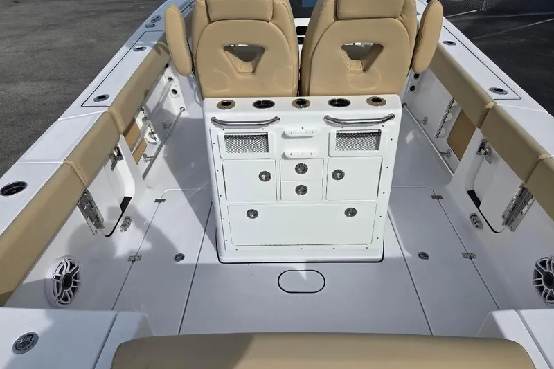 Slide: The Image of 2026 Sportsman Open 262 Center Console boat interior with tan seating and storage compartments. - 18