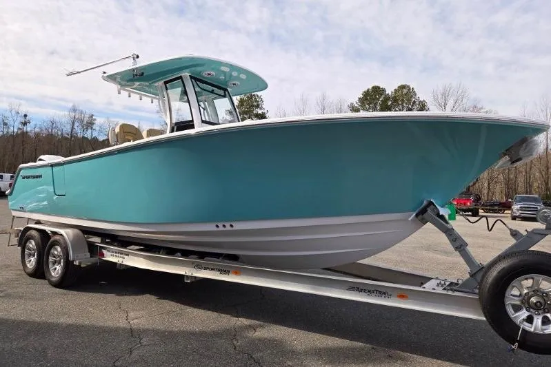 Slide: The Image of 2026 Sportsman Open 262 Center Console boat on trailer, turquoise hull, outdoor setting. - 8