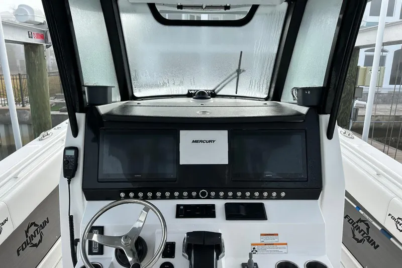 Slide: The Image of 2024 Fountain 38 Center Console boat dashboard with dual screens and steering wheel. - 20