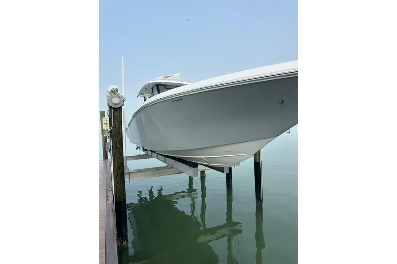 Slide: The Image of 2024 Fountain 38 Center Console boat on lift over calm water. - 23