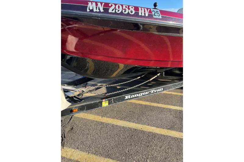 Slide: The Image of 2000 Ranger 619DVS Fisherman boat on trailer, red hull, parked in lot. - 2