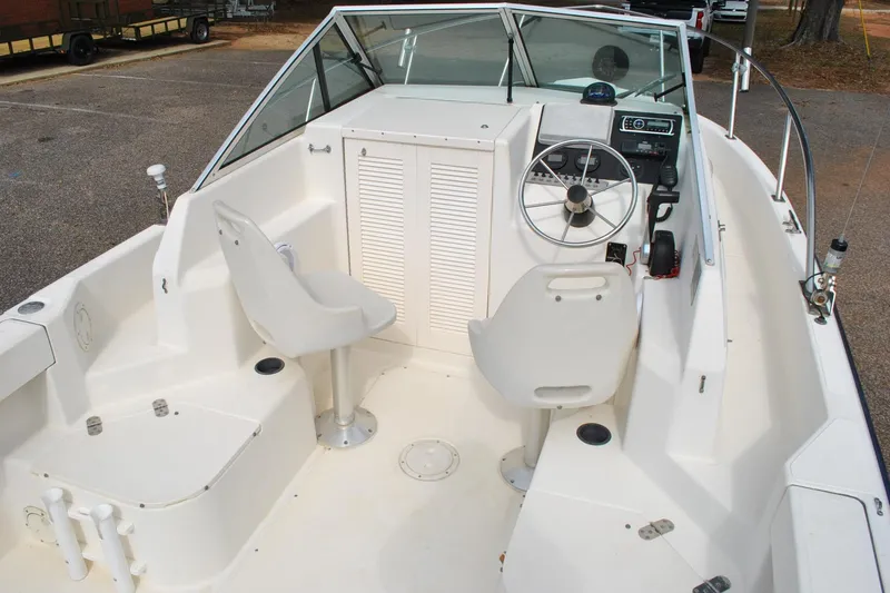 Slide: The Image of 1996 Pursuit 2150 Walkaround boat interior with steering wheel and seating. - 16