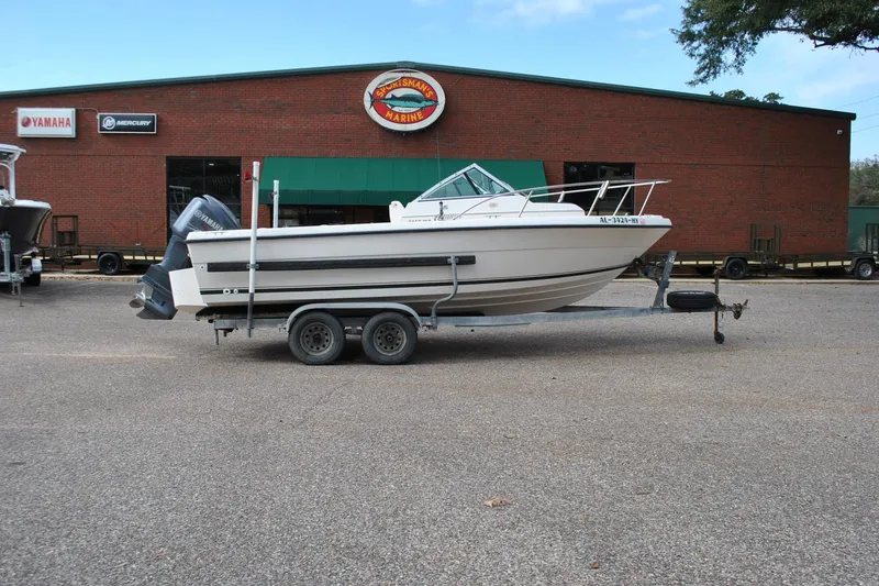 Slide: The Image of 1996 Pursuit 2150 Walkaround boat on trailer outside marine dealership. - 5