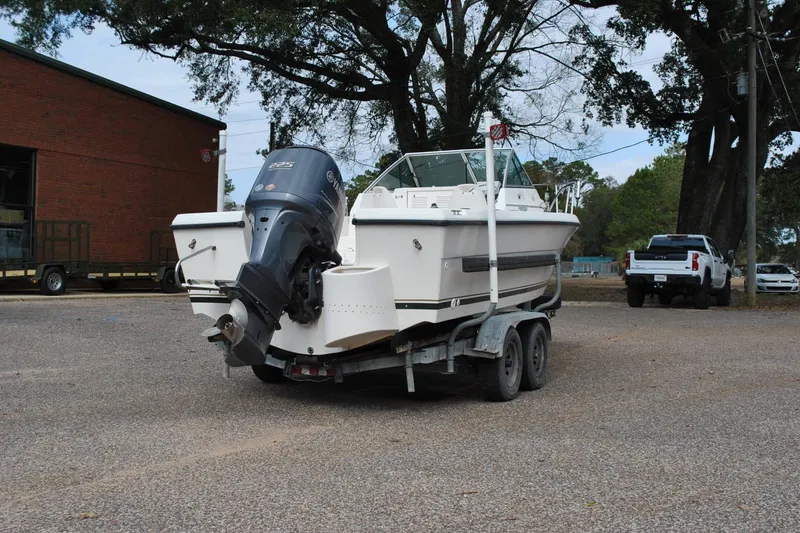 Slide: The Image of 1996 Pursuit 2150 Walkaround boat on trailer with outboard motor in parking lot. - 6