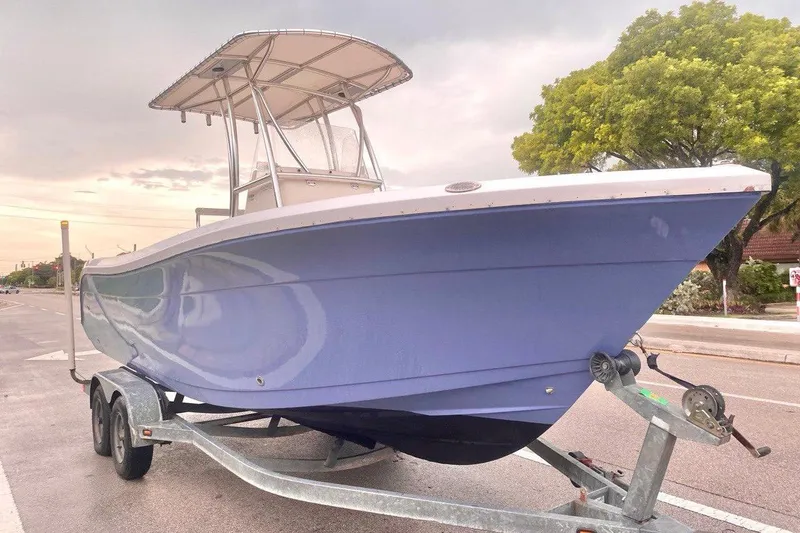 The Image of 2019 Cobia 220 Center Console boat on trailer, parked on street. - 0