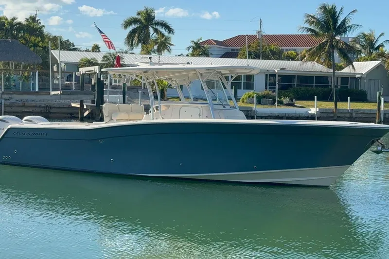 The Image of 2011 Grady-White Canyon 336 boat docked in sunny marina with palm trees. - 0