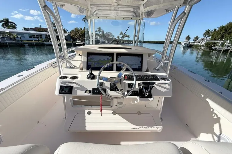 Slide: The Image of 2011 Grady-White Canyon 336 boat cockpit with steering wheel and navigation screens. - 1