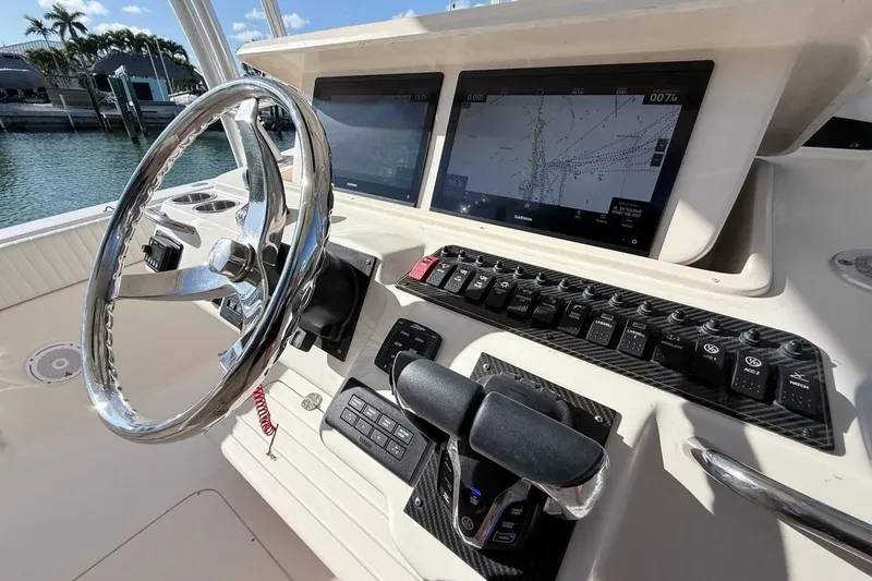 Slide: The Image of 2011 Grady-White Canyon 336 helm with steering wheel, navigation screens, and control panel. - 13