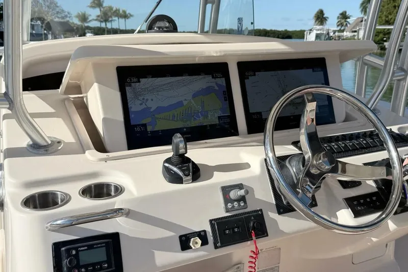 Slide: The Image of 2011 Grady-White Canyon 336 boat dashboard with navigation screens and steering wheel. - 14