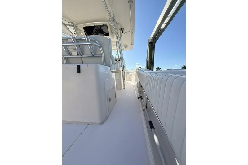 Slide: The Image of 2011 Grady-White Canyon 336 boat interior with seating and railing, under clear blue sky. - 21