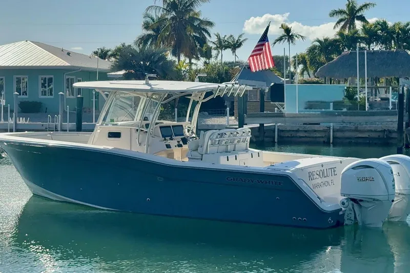 Slide: The Image of 2011 Grady-White Canyon 336 boat docked in sunny marina with palm trees. - 27