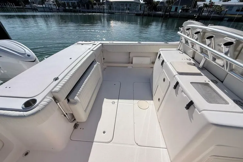 Slide: The Image of 2011 Grady-White Canyon 336 boat interior with seating and storage, docked by calm waters. - 6