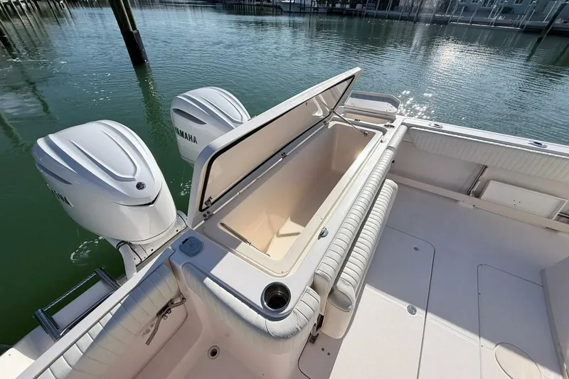 Slide: The Image of 2011 Grady-White Canyon 336 boat with Yamaha engines, open storage compartment, docked on calm water. - 7