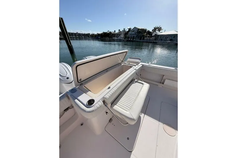 Slide: The Image of 2011 Grady-White Canyon 336 boat with open storage compartment, docked by waterfront homes. - 8