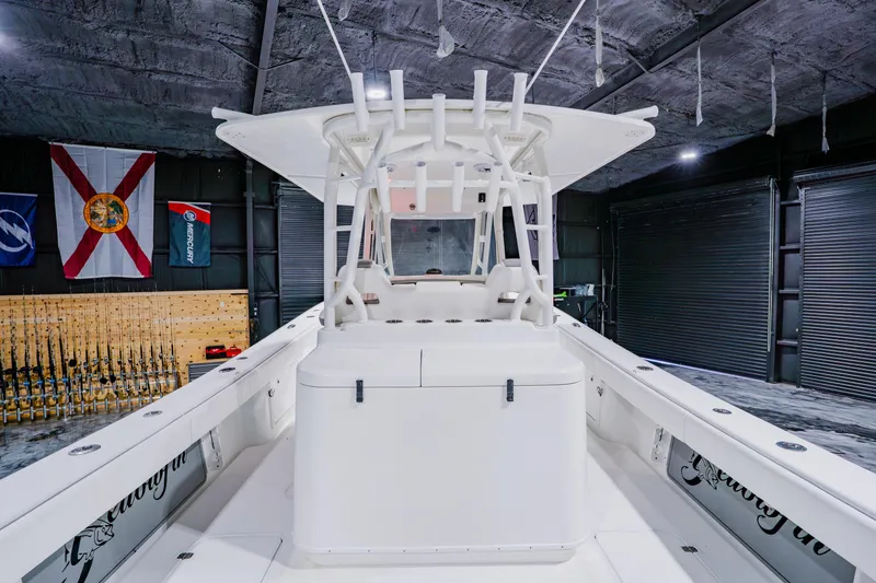 Slide: The Image of 2012 Yellowfin 39 Offshore boat in a garage with fishing rods and flags. - 26
