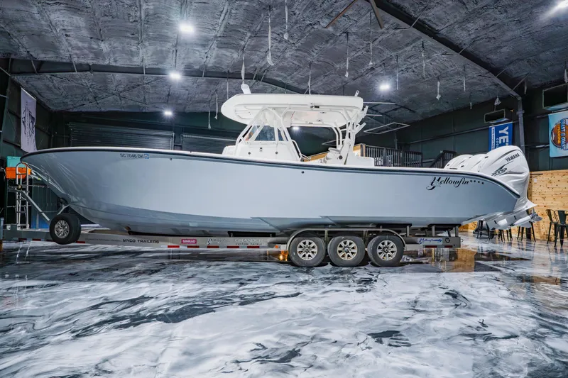 Slide: The Image of 2012 Yellowfin 39 Offshore boat on trailer in a spacious indoor setting. - 5