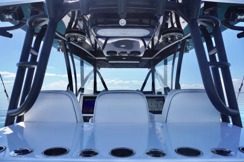 Slide: The Image of 2019 SeaHunter 45 Tournament boat interior with helm and seating, under clear blue sky. - 26