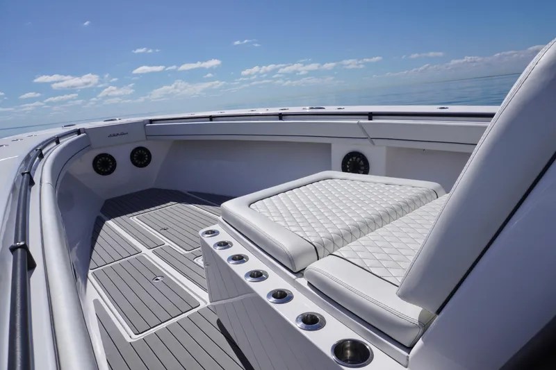 Slide: The Image of 2019 SeaHunter 45 Tournament boat interior with cushioned seating and cup holders, under clear skies. - 28