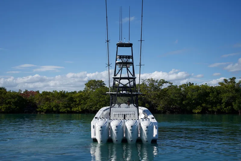 Slide: The Image of 2019 SeaHunter 45 Tournament boat with multiple engines, docked near lush greenery. - 4