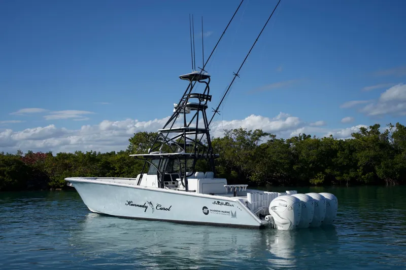 Slide: The Image of 2019 SeaHunter 45 Tournament boat with multiple engines on calm water, surrounded by greenery. - 8