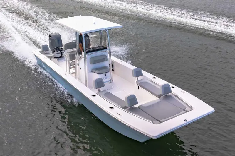 Slide: The Image of 2026 Bay Rider 2460 FS Skiff boat with T-top and seating, displayed outdoors. - 19