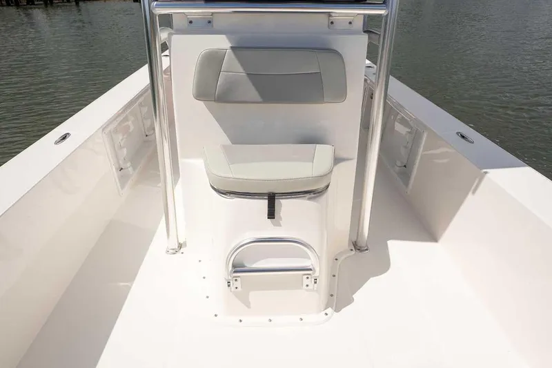 Slide: The Image of 2026 Bay Rider 2460 FS Skiff boat interior with seating and motor, displayed outdoors. - 23