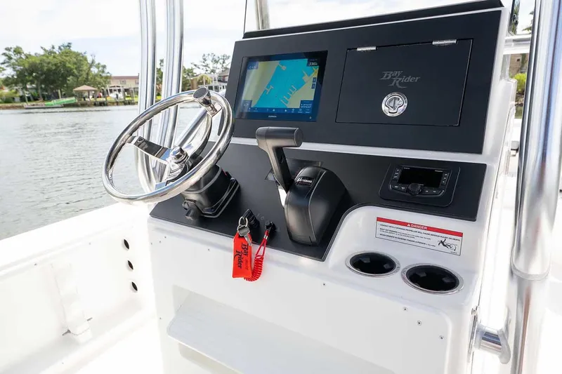 Slide: The Image of 2026 Bay Rider 2460 FS Skiff console with steering wheel and controls. - 25
