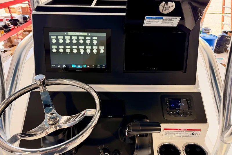 Slide: The Image of Control panel of 2026 Bay Rider 2460 FS Skiff with steering wheel and digital display. - 30