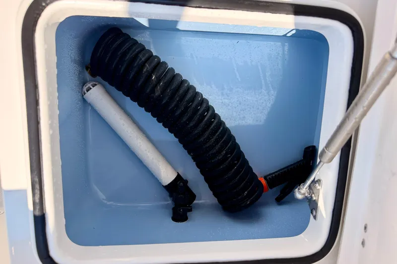 Slide: The Image of Storage compartment of 2026 Bay Rider 2460 FS Skiff with hose and pump. - 36