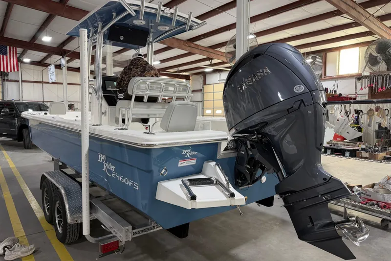 Slide: The Image of 2026 Bay Rider 2460 FS Skiff boat on trailer, side view in outdoor setting. - 4